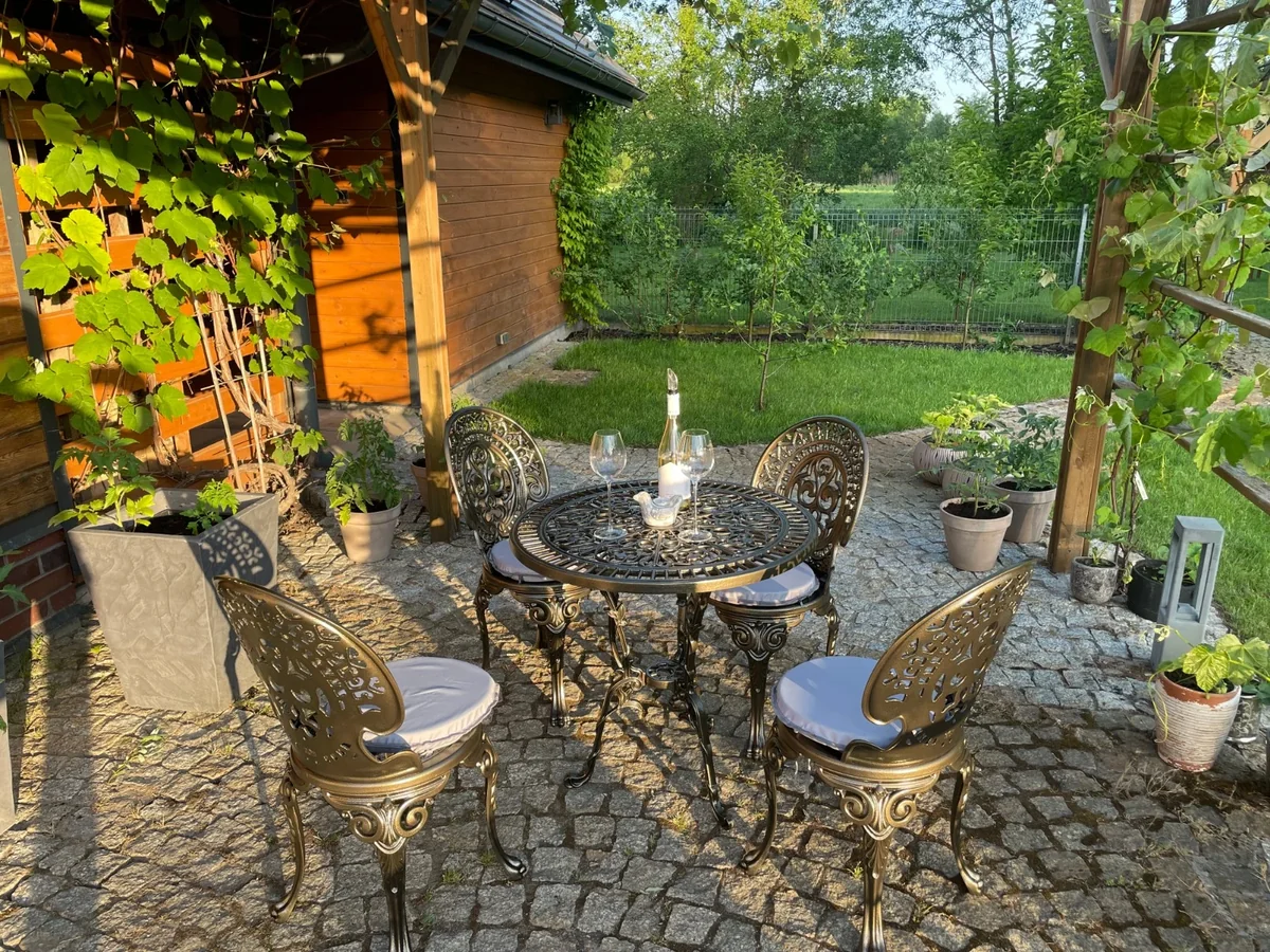 Romantic-Gartenmöbelset in Antikgold mit vier Stühlen auf einer Gartenterrasse; Sitzkissen und Dekoration nicht im Lieferumfang