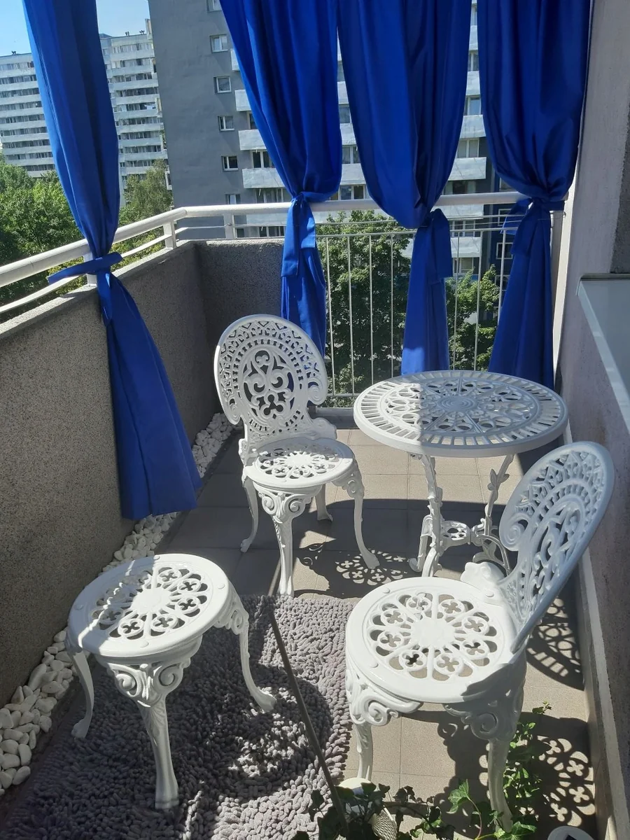 Weißes Romantic-Set auf einem Balkon mit zwei Stühlen; zusätzlicher Hocker nicht im Lieferumfang