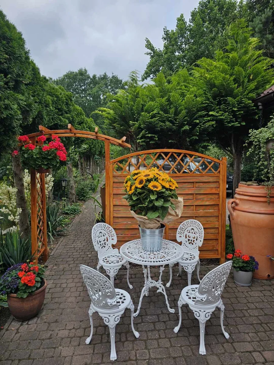 Weißes Romantic-Gartenmöbelset mit vier Stühlen im Garten; Dekoration nicht im Lieferumfang